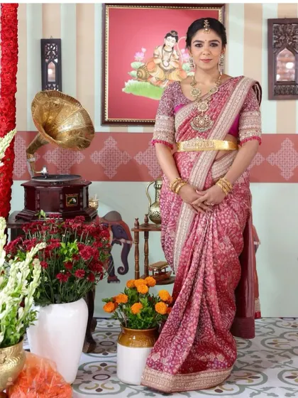 This client looks like a doll in her pink bandhani saree. I designed a matching blouse with delicate embroidery, creating a look of timeless elegance for a family function.