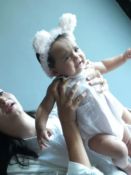 A mother lifts her baby up in a playful moment. We aim to capture these dynamic and loving interactions that show the unique personality of your family.