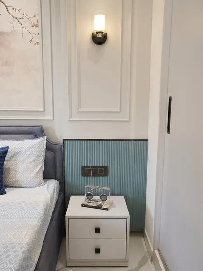 A close-up of the bedside table and the fluted paneling. It's these small, consistent details that tie the whole room's design together.