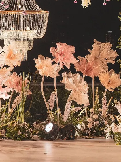 Another perspective of the beautifully lit paper flowers and crystal chandeliers. The combination of soft textures and sparkling light against the night sky created a truly enchanting visual.