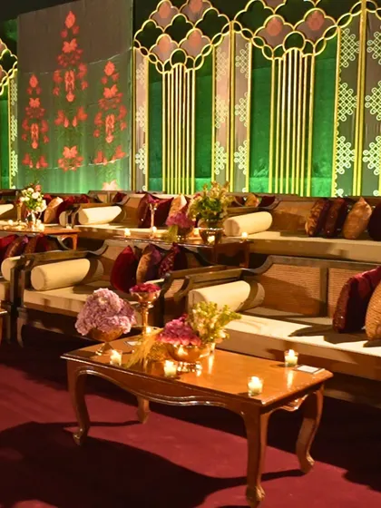 A luxurious lounge area with plush seating and intricate decor. The warm lighting and rich colours create an inviting space for guests to relax and enjoy the festivities.