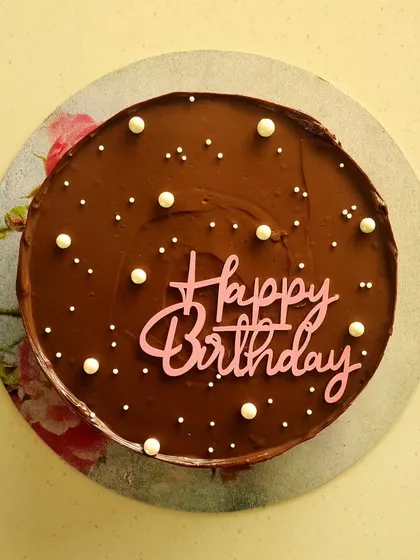 A simple and elegant Kahlua infused chocolate cake made for a special mom's birthday. The smooth ganache is decorated with delicate sugar pearls and a lovely birthday topper.