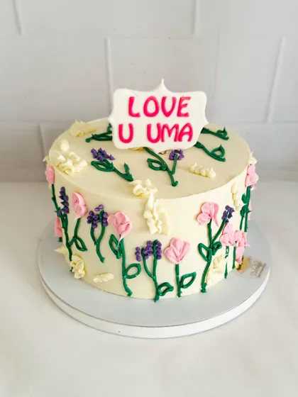 A charming cake with hand-piped wildflowers, giving it a rustic and sweet "meadow" look.