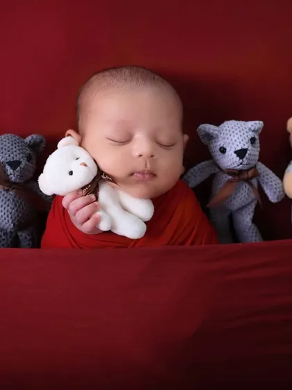 A lineup of tiny teddy bears watches over the sleeping newborn. This adorable composition is playful and highlights just how small and precious your baby is.