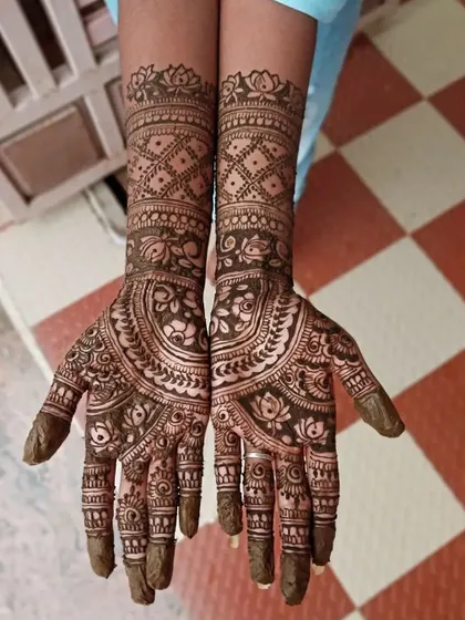 A beautiful, full-hand mehendi design with a mix of floral and paisley motifs. The intricate patterns cover the entire palm and fingers, perfect for a festive look.