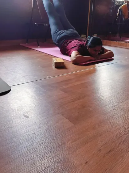 Rest and recovery are key parts of yoga therapy. This student is in a restorative pose with her legs elevated on a chair, a simple but powerful way to relieve tired legs and calm the nervous system.