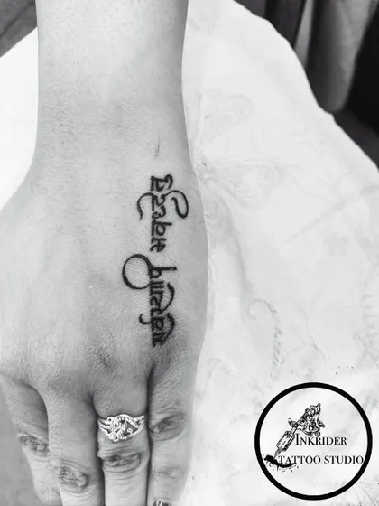 A beautiful script tattoo on the hand, showing our skill in creating elegant calligraphy for a highly visible placement.