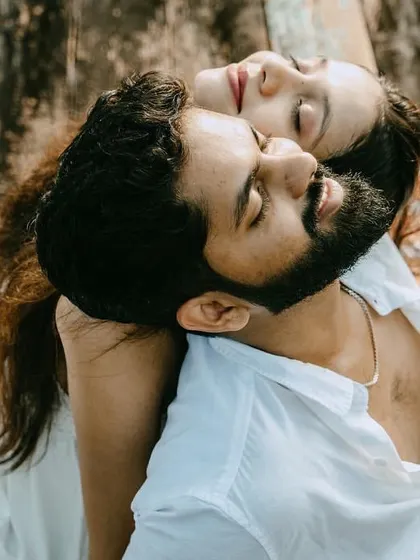 A close-up of the couple relaxing on a picnic blanket. The unique angle and their peaceful expressions make this a very intimate and artistic shot.