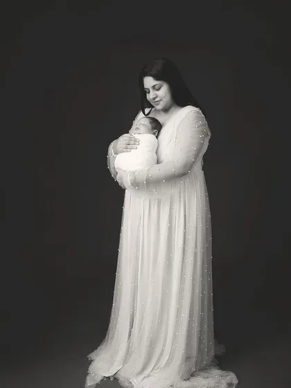 A mother's embrace, captured in timeless black and white. The focus is on the serene expression and the gentle way she holds her new baby.