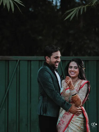 A happy couple portrait taken outdoors at their reception, their smiles genuine and full of love.