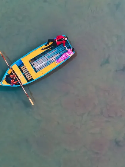 An aerial shot of a couple enjoying a peaceful boat ride, a perfect moment captured during their pre-wedding shoot.