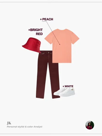 This look pairs wine-colored trousers with a peach t-shirt and a bright red bucket hat. White sneakers keep the outfit grounded and casual.