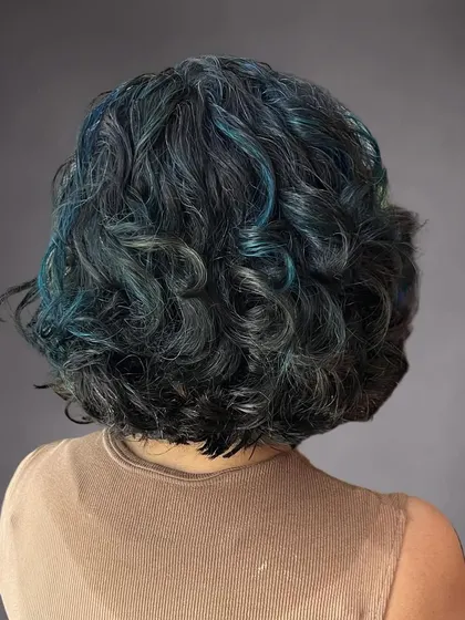 The back view of Nikita's unique blue-highlighted curly hair.