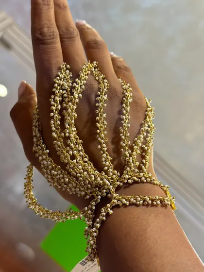 A close-up of our bestselling pearl hand harness. I designed this piece to be delicate yet make a statement, with cascading strands of tiny pearls that beautifully adorn your hand for any festive occasion.