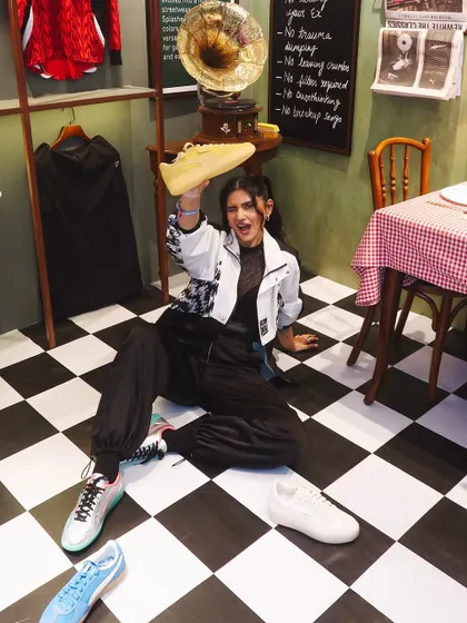 A fun, playful shot of me on the floor surrounded by different colorways of the Puma Palermo sneakers.