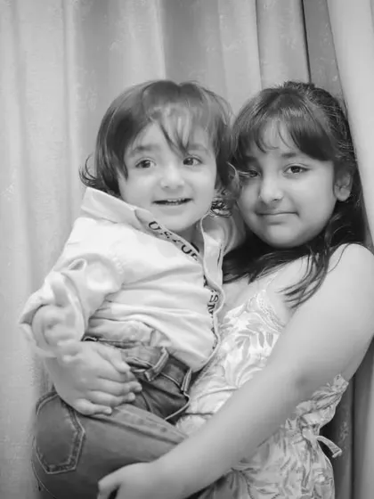 A black and white version of the sibling portrait, highlighting their sweet embrace and expressions.