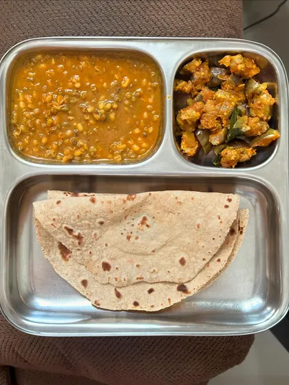 A simple home-style meal of chapati, whole green gram dal, and sautéed brinjal.