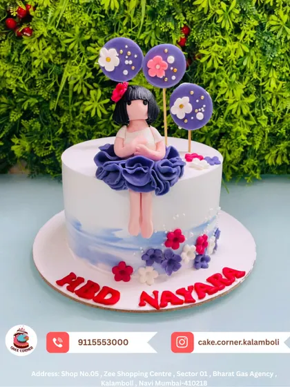 A cute doll cake with floral lollipop decorations. The purple and red details make this a vibrant and fun cake for Nayara's birthday.
