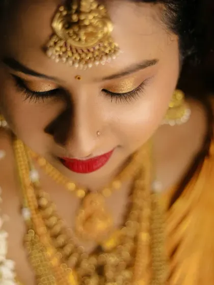 A soft, artistic close up of a bride, focusing on her beautiful eye makeup and the warm glow of the lighting.