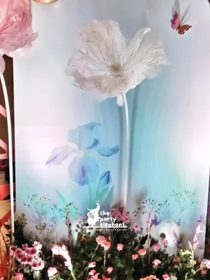 A close-up of the delicate organza flower and butterfly details on the backdrop. These handcrafted elements add a touch of elegance and fantasy.