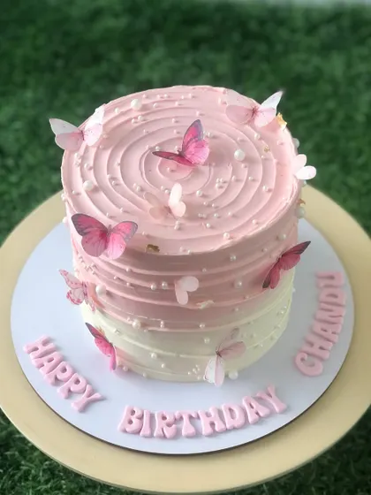 The full view of the pink ombre butterfly cake with a "Happy Birthday" message.