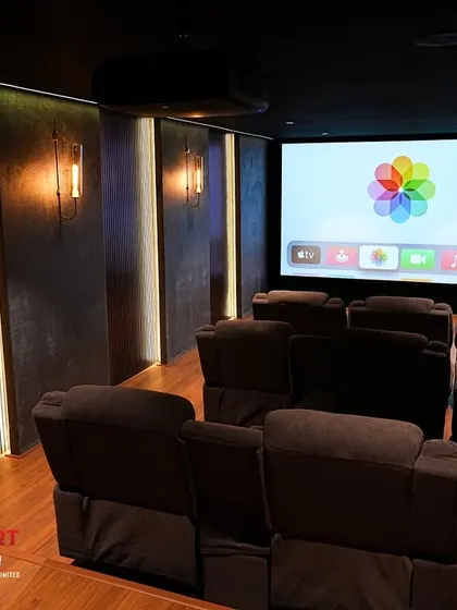 This shot shows the harmonious blend of different materials, including wood-paneled floors, textured wall coverings, and plush fabric recliners.
