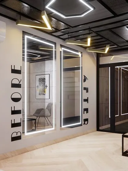The waiting lounge at the gym features comfortable seating, modern decor, and mirrors with integrated lighting. It's a stylish and comfortable space for clients to relax before or after their workout.