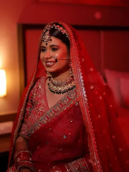 A classic red bride, ready for her big day. The makeup is timeless, with a soft focus on the eyes and a radiant smile that lights up the room.