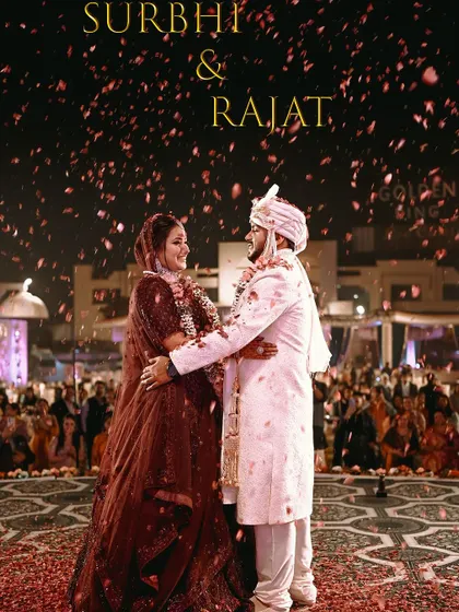 A stunning shot of the couple during their Varmala, with a shower of rose petals creating a magical and romantic atmosphere.