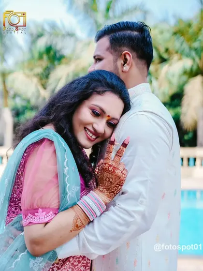 A fun and candid shot of the bride hugging the groom from behind and making a peace sign. This photo captures their playful and happy relationship.