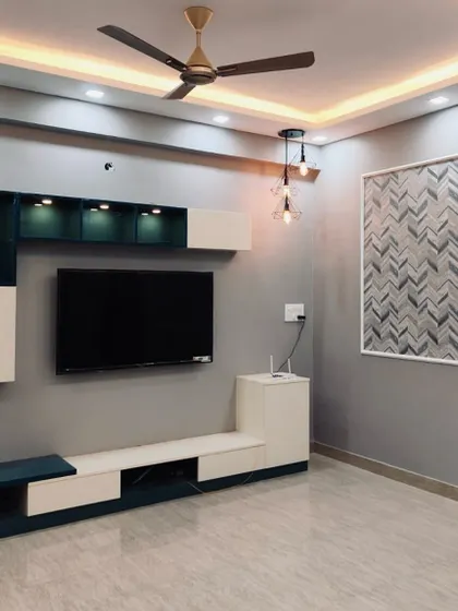 A modern TV unit in a two-tone design with integrated shelving and ambient lighting, set against a cool grey wall with textured panels.
