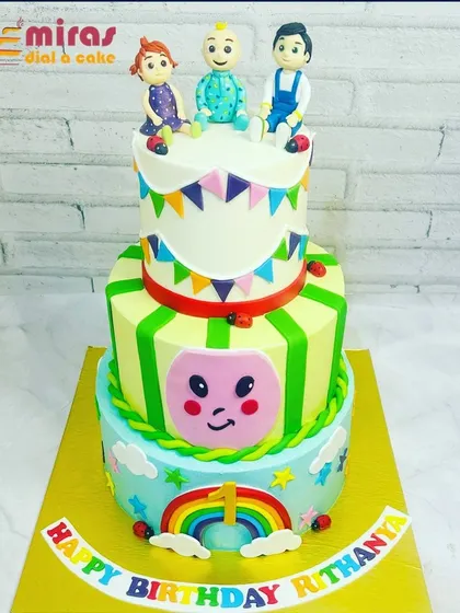 This grand three-tier Cocomelon cake is perfect for a big first birthday bash. It features the whole gang, a rainbow, and colorful bunting, capturing all the joy of the show.
