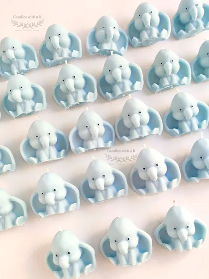 A batch of 50 baby elephant shaped soy wax candles in a calming light blue. These standalone candles are perfect for themed parties and are scented with jasmine.
