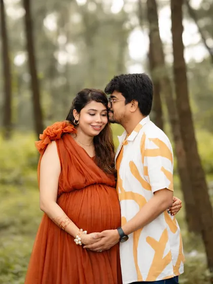A sweet moment during a maternity shoot. The dad-to-be gently kisses his partner's forehead as they await their new arrival.