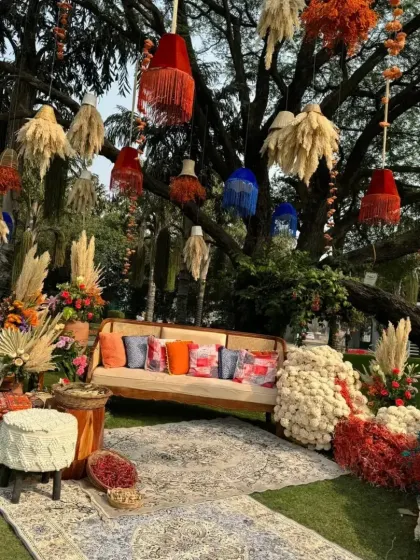 A vibrant and bohemian-themed Mehendi seating area. I designed this outdoor space under a large tree, using colorful hanging tassels, pampas grass, and eclectic furniture to create a relaxed and festive atmosphere for the celebration.