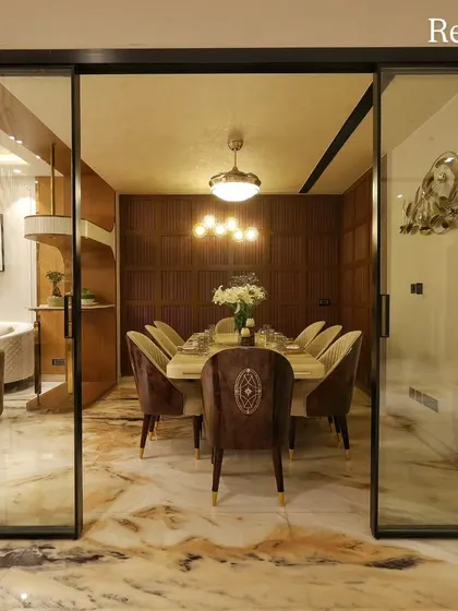 The final reality of the Harmony Home dining room, seen through elegant sliding glass doors. The design features rich wood paneling and a statement metal wall art piece.