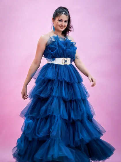 A joyful, welcoming pose in the vibrant blue gown.
