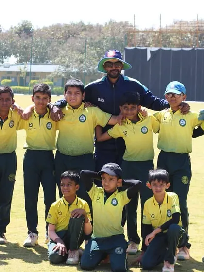 The SST Cricket Academy junior team poses for a photo with their coach.