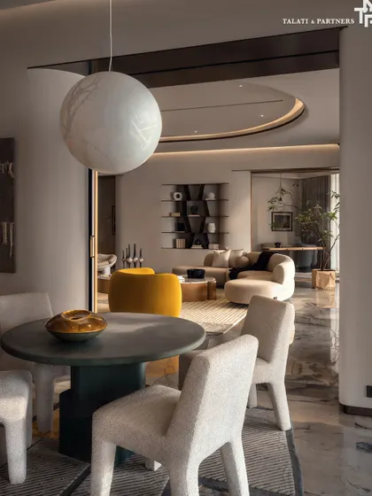 A view from a small dining nook into the magnificent living room of the Palais Royale apartment. The design embraces quiet luxury, where every detail is curated to evoke calm, depth, and effortless elegance against panoramic views of the Arabian Sea.