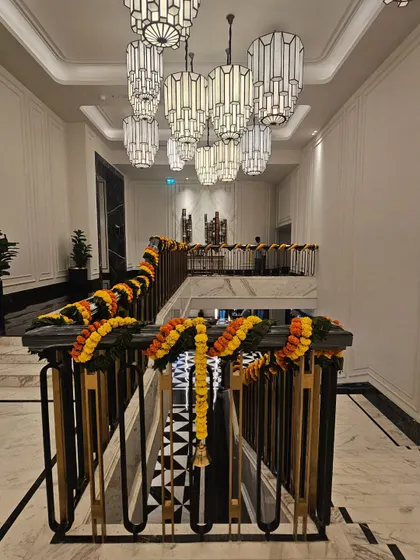 To extend the festive atmosphere, I decorated the hotel's grand staircase railings with matching marigold garlands. This ensures a cohesive decorative theme from the entrance throughout the main public areas of the venue.