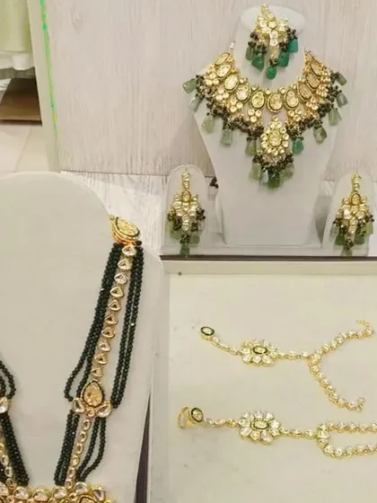 For a touch of royalty, rent this stunning Kundan and emerald green bead jewellery set. It includes a choker, long necklace, and matching earrings.