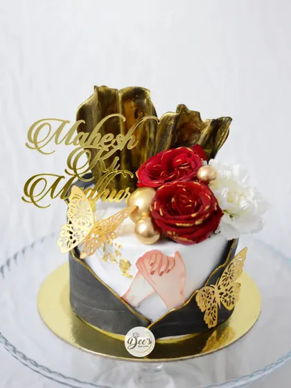 This anniversary cake is designed to be a complete gift. The elegant black, white, and gold design is presented within a beautiful floral frame, creating a truly special experience.