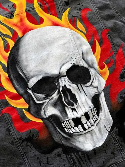 A close-up of the flaming skull artwork. I spent many hours layering paint to create the depth and detail in the bone and flames, using flexible acrylics designed for fabric.