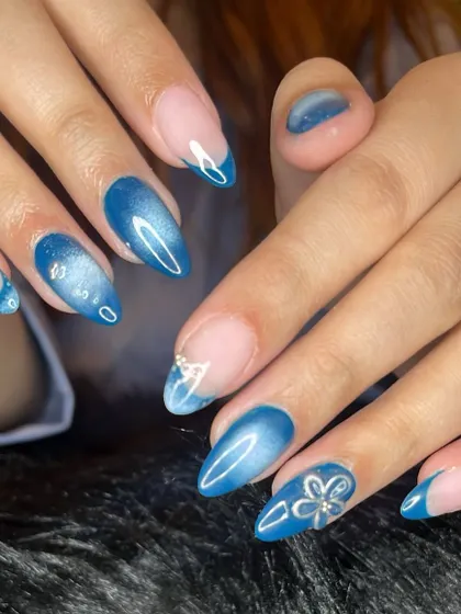 A beautiful blue aura nail set with cat eye effects and silver chrome accents.