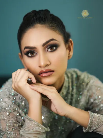 This beauty shot shows the stunning makeup look created to complement the silver-grey gown, featuring a dramatic smoky eye and glossy nude lip.