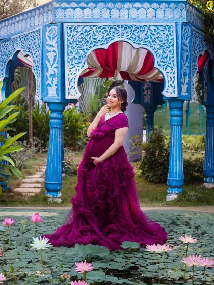 The mom-to-be looks like a princess in this shot by the lily pond, her purple gown a vibrant splash of color.