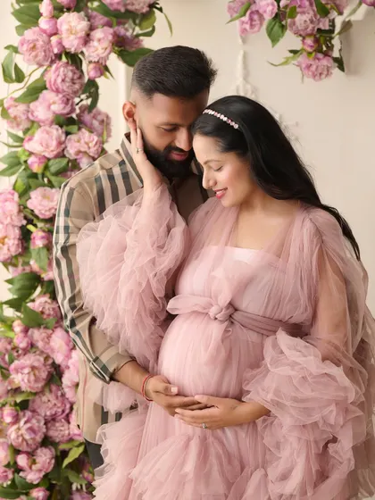 We believe maternity photos should be as magical as the life you're creating. In this fine-art maternity portrait, we used a cascade of pink peonies and a flowing tulle gown to create a dreamy, romantic atmosphere for the expecting couple.