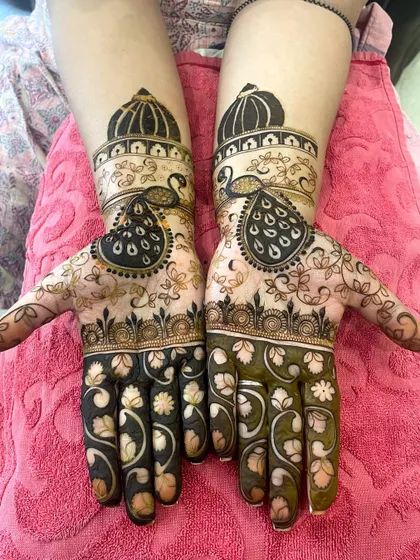 A grand design for Teej, featuring peacocks with architectural domes on their heads. The palms are filled with a mix of floral and geometric patterns.