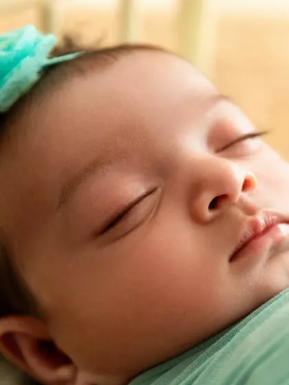 A detailed close-up of a newborn's face, showing their delicate eyelashes and lips. These macro shots capture the tiny details.