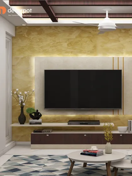 A luxurious TV unit with a golden-hued textured back panel and a dark wood console. The floating shelf above the TV adds a light touch, perfect for displaying minimalist decor.